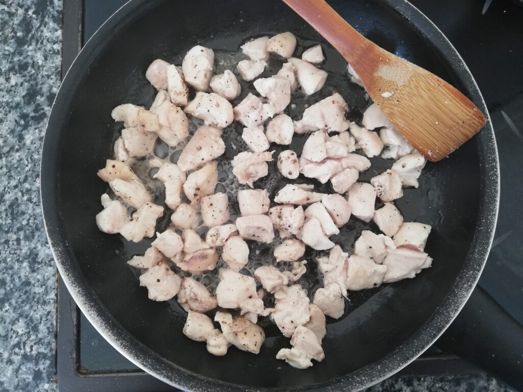 cubed chicken breast cooking in a skillet