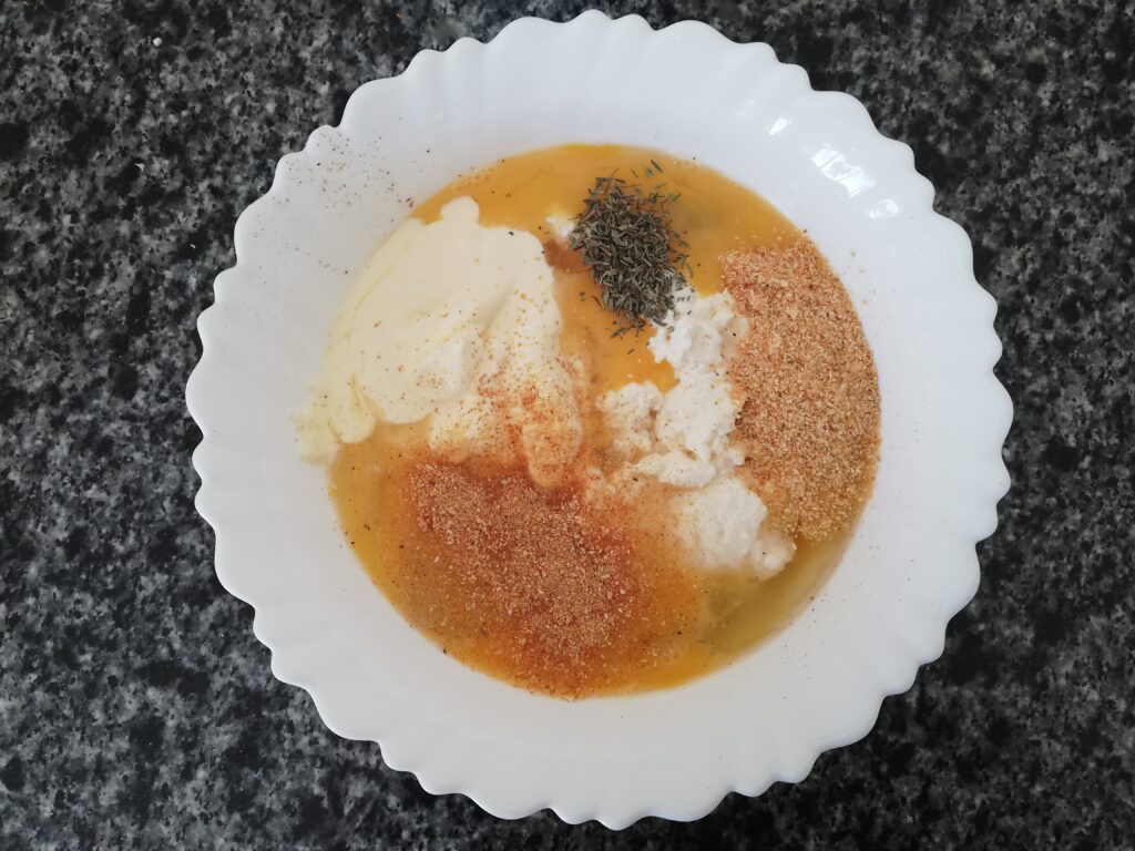 eggs cream milk cottage cheese and spices in a white bowl