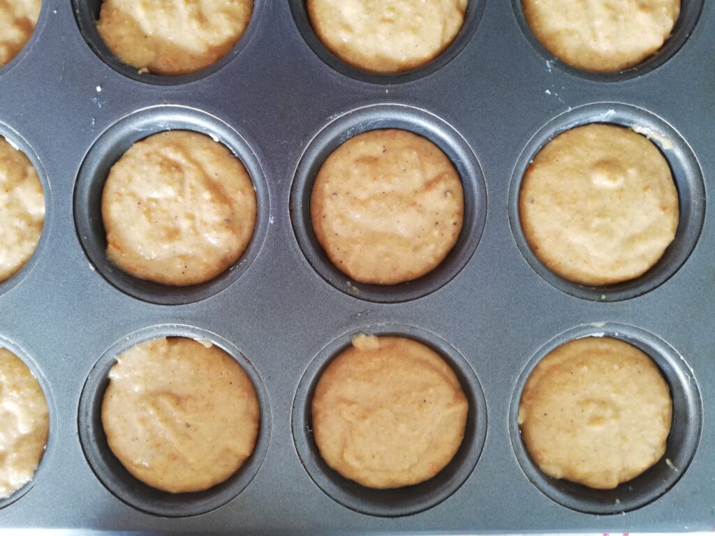 metal muffin pan with muffin batter