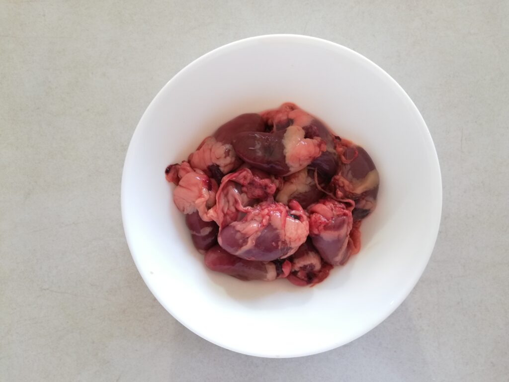 chicken hearts in a white bowl