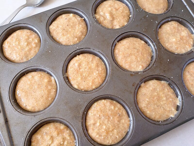Filling muffin pan with pumpkin muffin batter