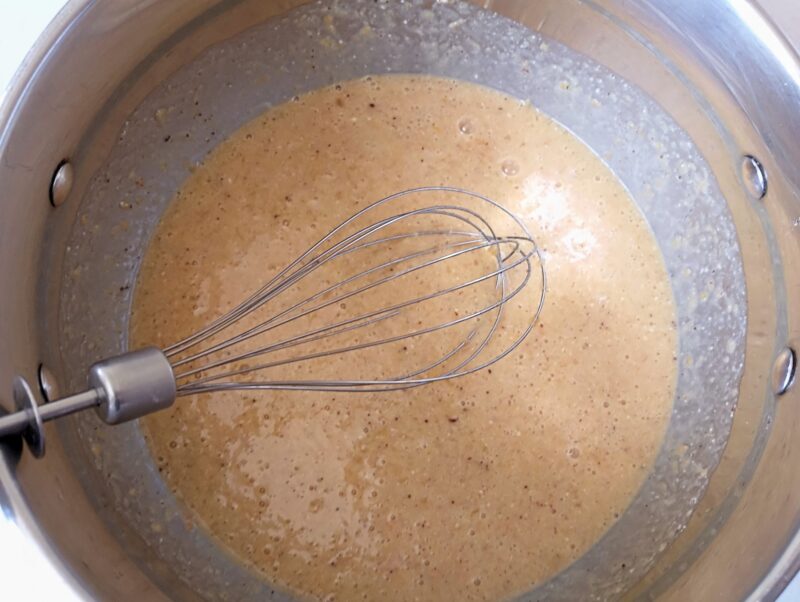 Whisking eggs, pumpkin puree, cream, sugar, and spices in bowl