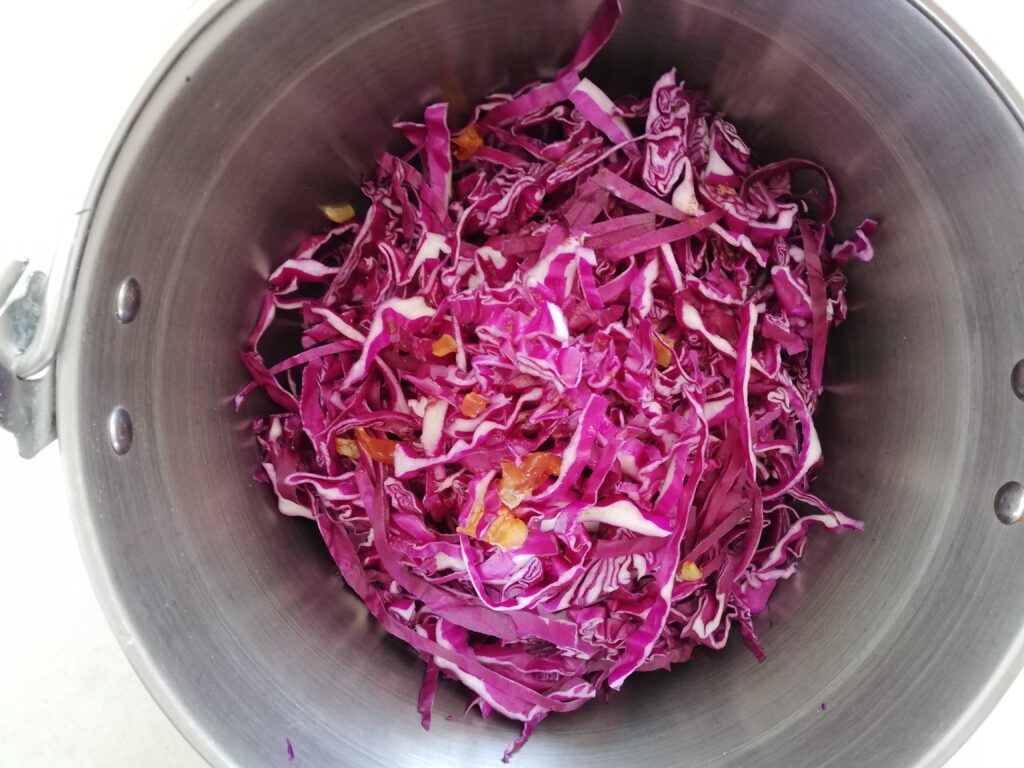 jam pot filled with shredded red cabbage with ground cloves and some orange marmalade on top