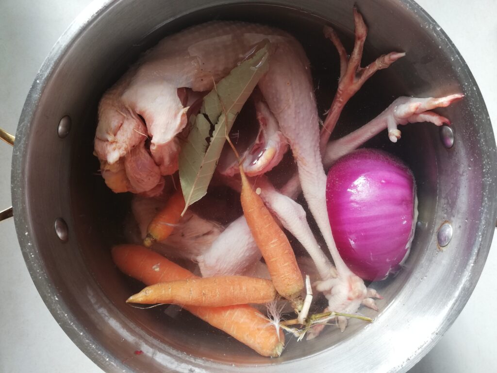 stockpot with old hens carrots onion bay leaf and water