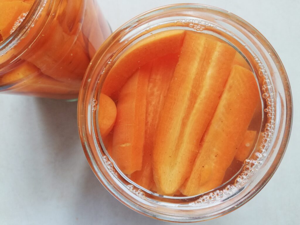 Jars of lacto-fermented carrots on counter