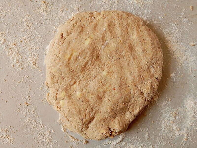 Patting the sourdough biscuit dough into thick circle on floured counter