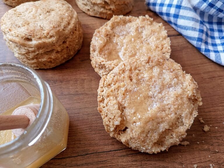 Sourdough whole wheat biscuit cut in half and spread with butter and honey