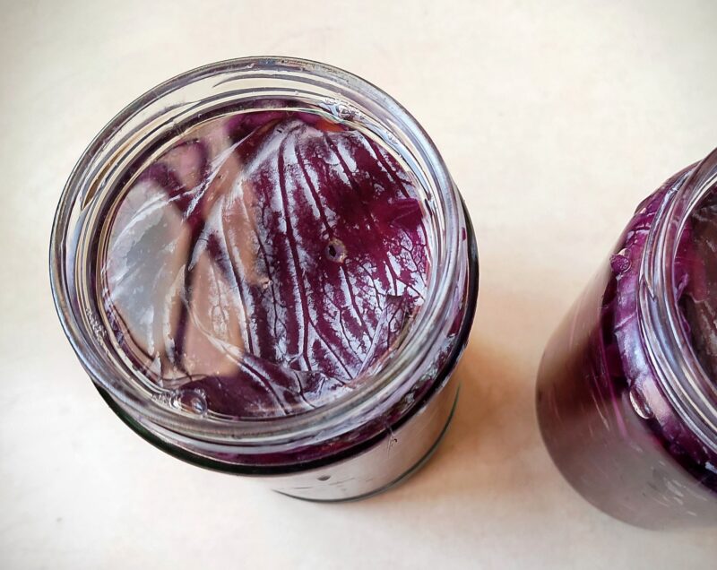 Topping jars of red cabbage with a little brine