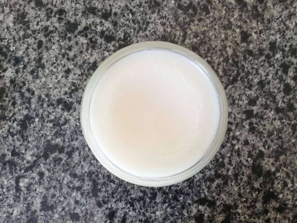 a jar of rendered tallow standing on a marble counter top