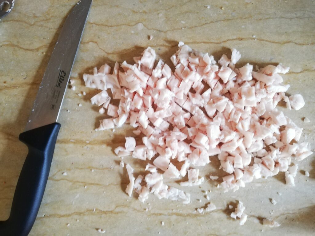 chopped fat and a large knife on a marble counter top
