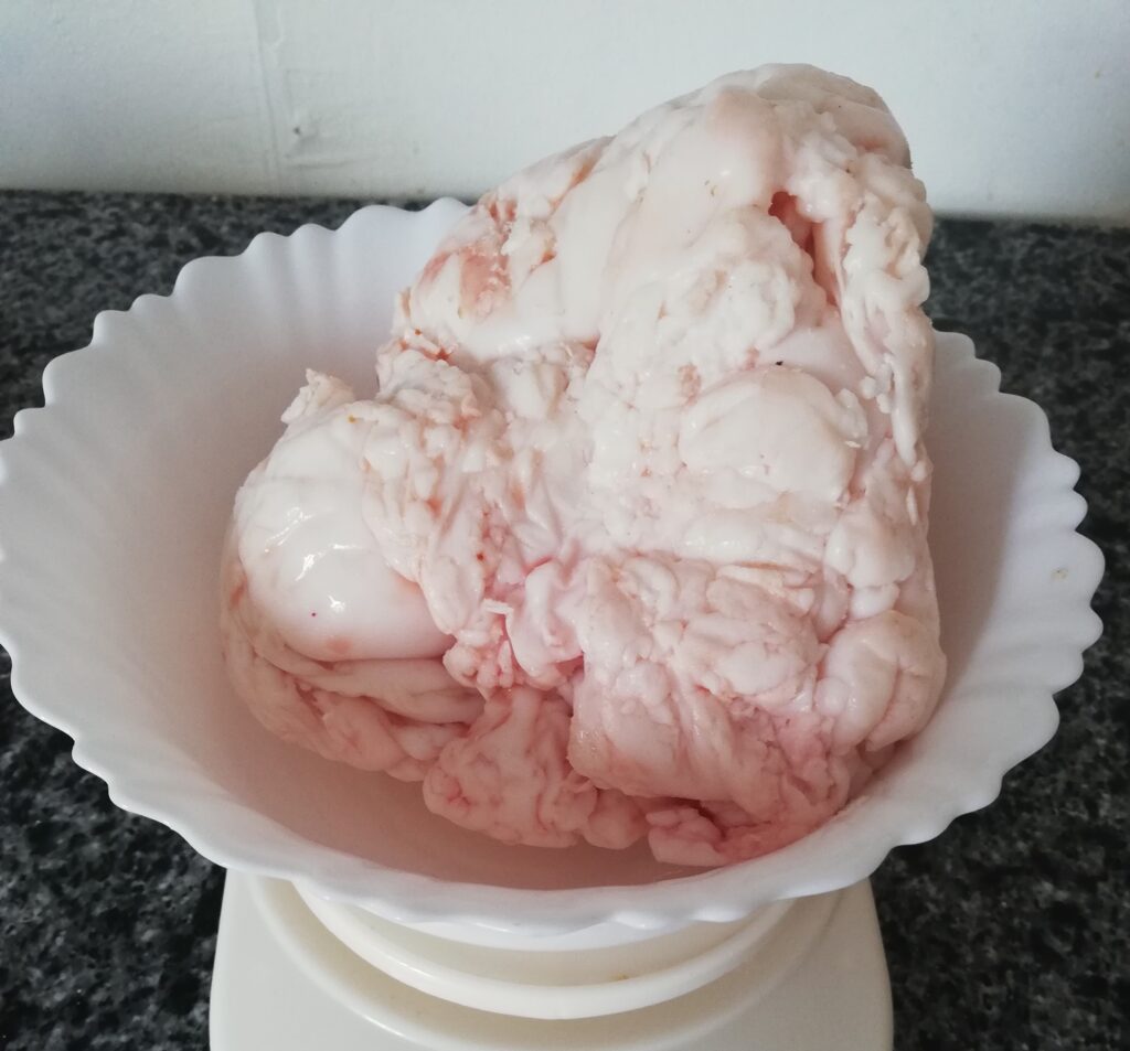 a lump of suet in a white bowl on the kitchen scale