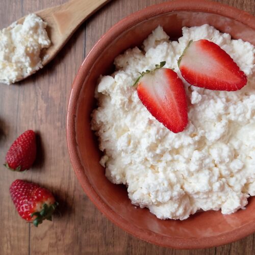 Raw milk cottage cheese recipe: bowl of cottage cheese on wooden table