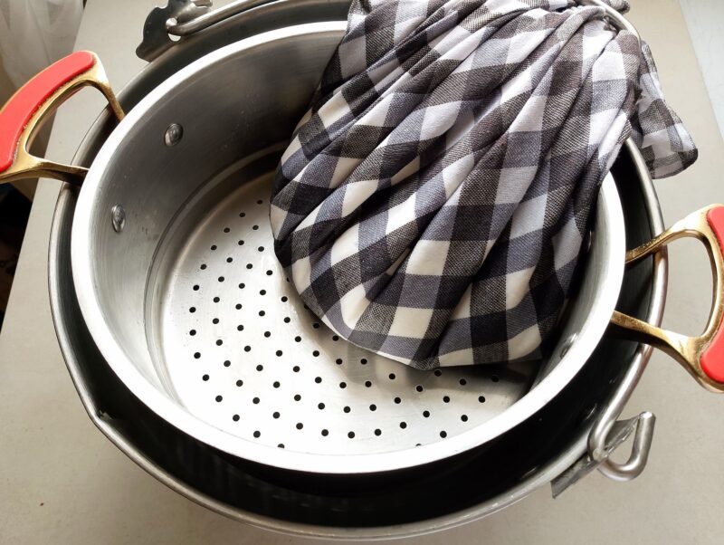 Bundling the cottage cheese in cheesecloth to speed up draining of whey