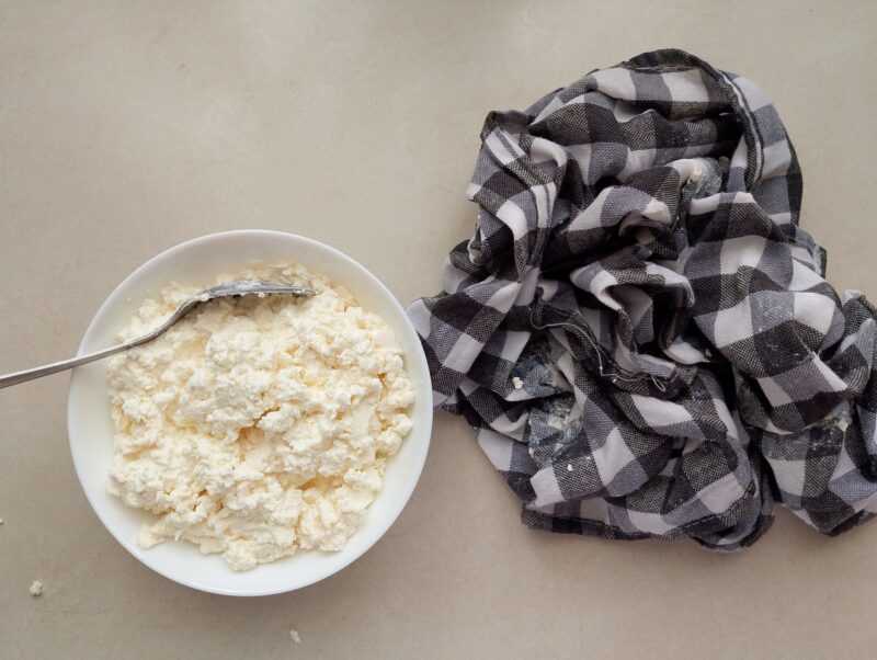 Transferring ready cottage cheese from cheesecloth to bowl