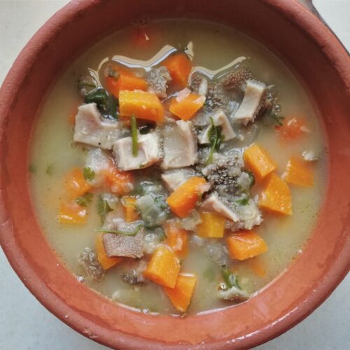 Tripe soup with vegetables in a clay bowl