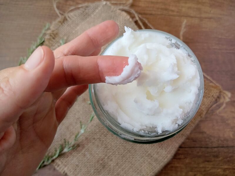Hand scooping some whipped tallow out of a jar