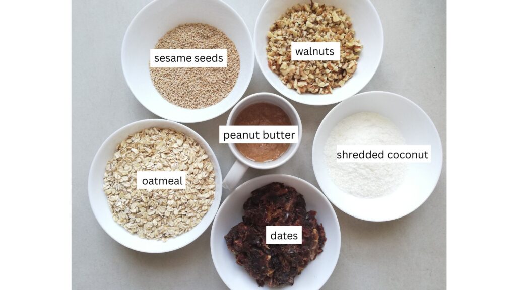 a bowl of sesame seeds a bowl of chopped walnuts a bowl of shredded coconut a bowl of chopped dates a bowl of oatmeal and a cup with peanut butter in the middle