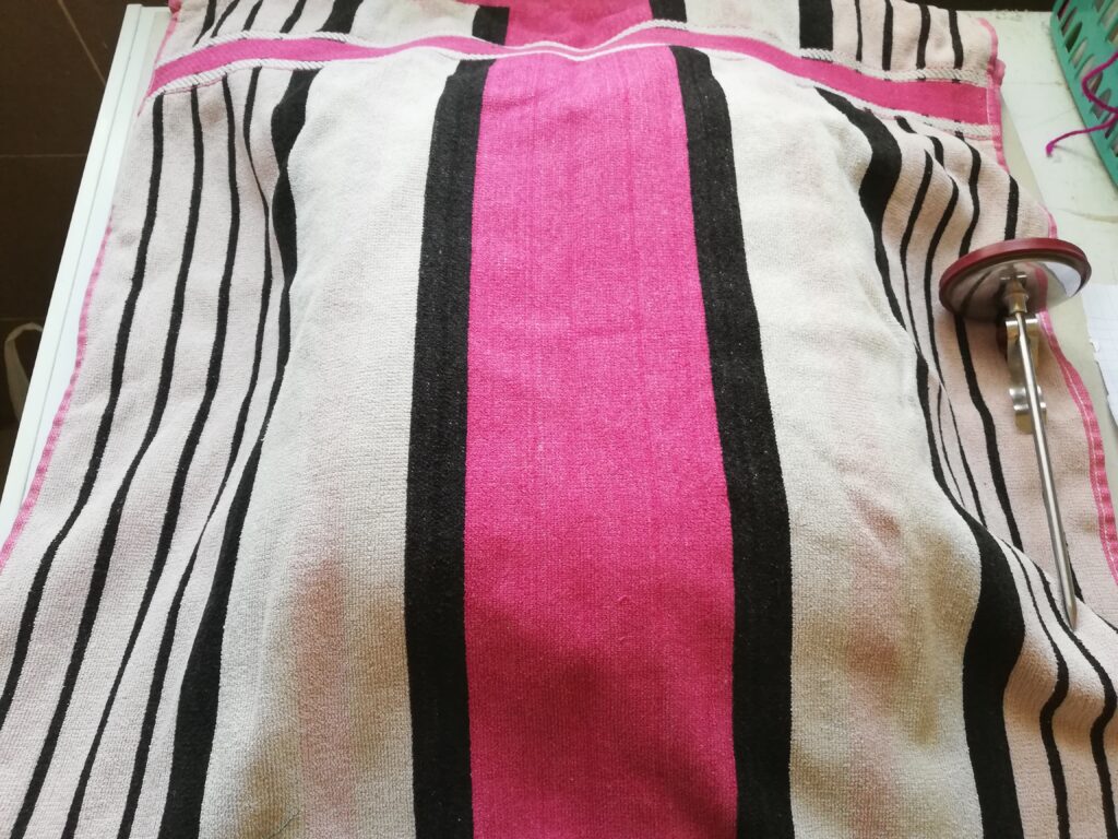 mold with pumpkin spice soap covered with a pink stripy towel with a thermometer on the right