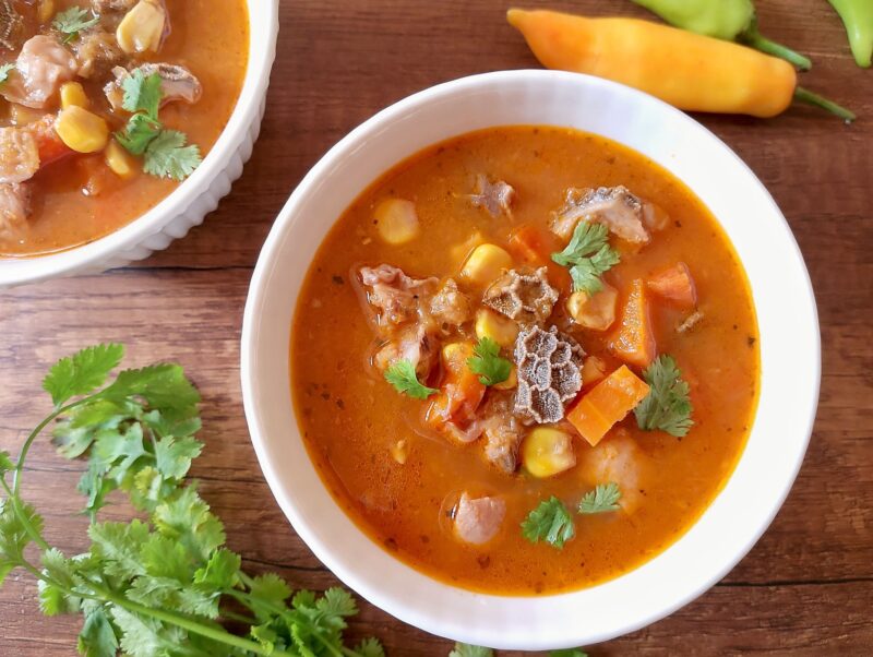 Red menudo soup in bowl garnished with cilantro
