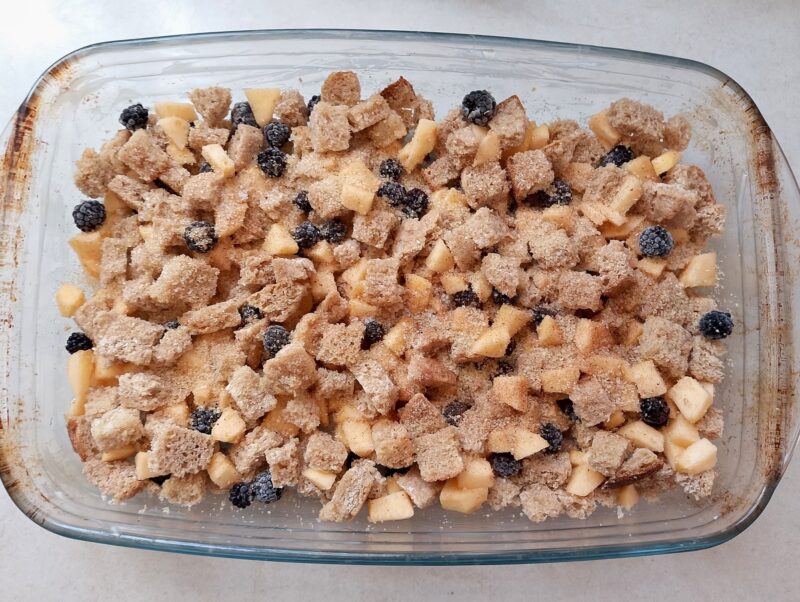 Sprinkle cubed bread and fruit with sugar and cinnamon in dish