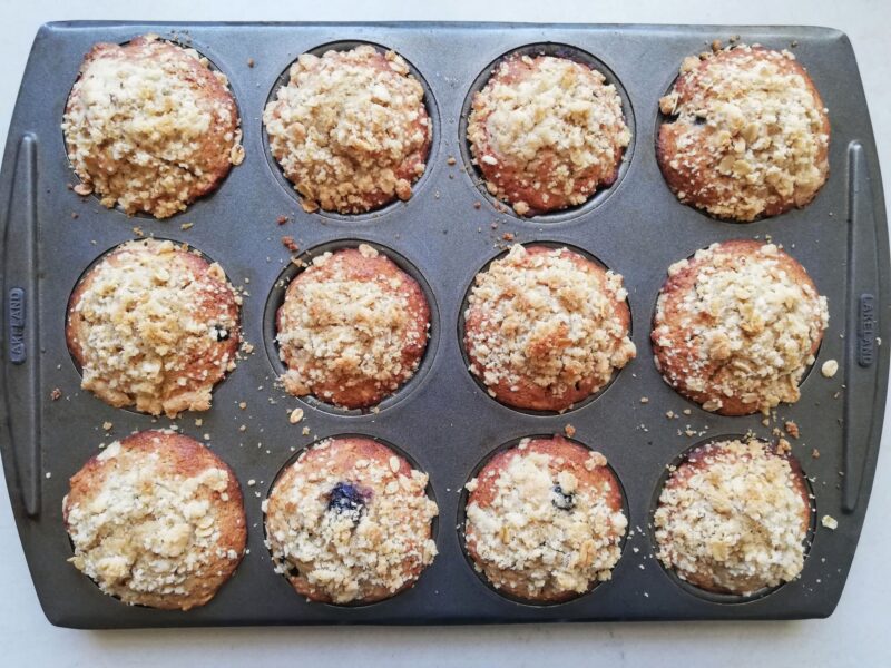 Freshly baked sourdough muffins cooling in the pan