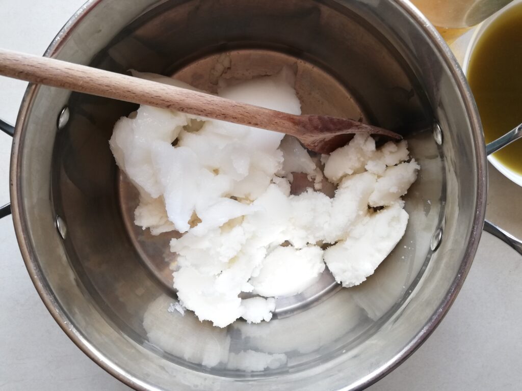 Melting fats in a pot in preparation for making soap