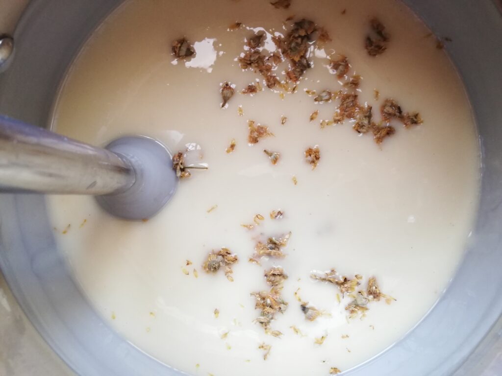Adding chamomile flowers into the soap base at light trace