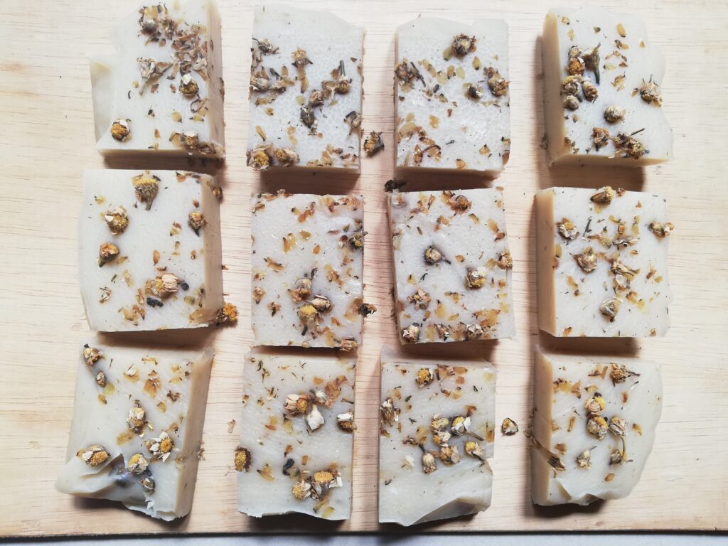 Chamomile soap cut into bars, curing on a large wooden tray