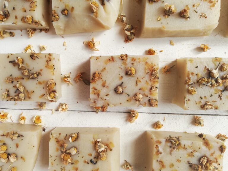 bars of chamomile soap with chamomile flowers scattered around