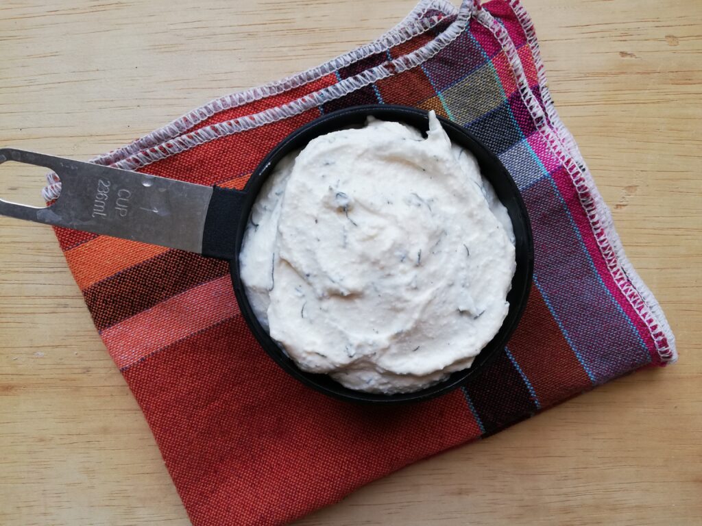 Cottage cheese dip in a measuring cup ready to be placed in the refrigerator to chill before serving