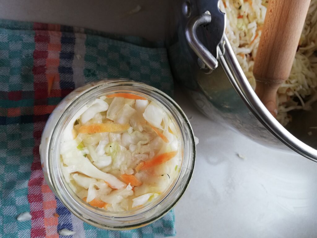 A jar packed with curtido ready to have brine added on top