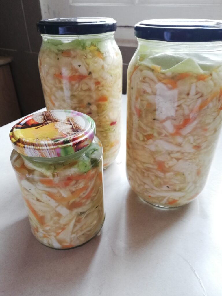 Jars of curtido with lids screwed on tight ready to be fermented