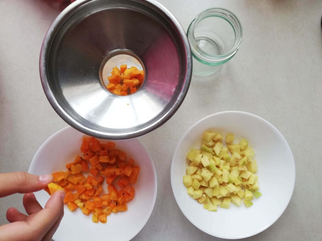 Chopped fresh turmeric and ginger in bowls ready to be put into jars