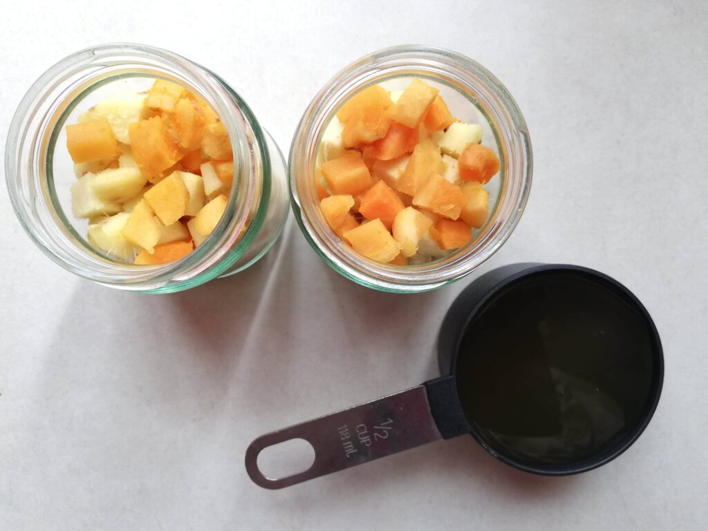 Jars filled with chopped fresh turmeric and ginger ready to be mixed with raw honey