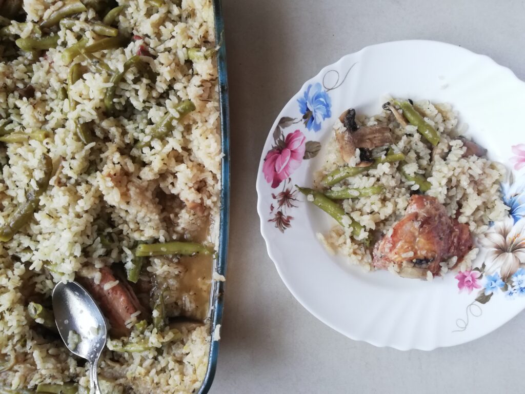 Casserole dish with baked risotto and some baked risotto in a plate ready to be served