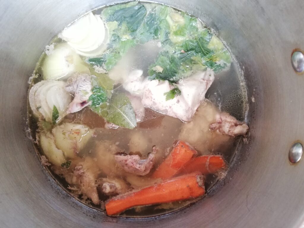 Chicken bone broth simmering in a stainless steel pot
