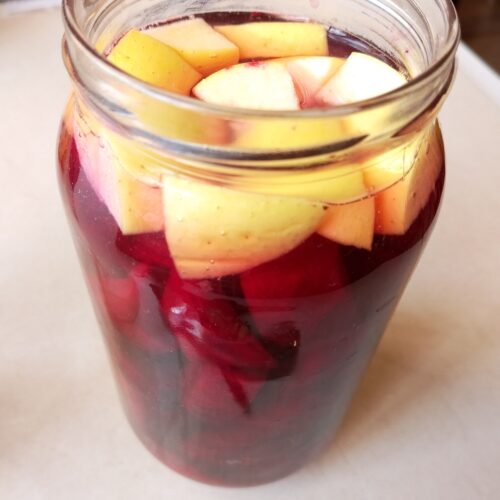 A jar of beet and apple kvass ready to be fermented