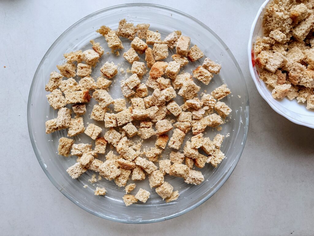 Cubed sourdough bread spread in a casserole dish