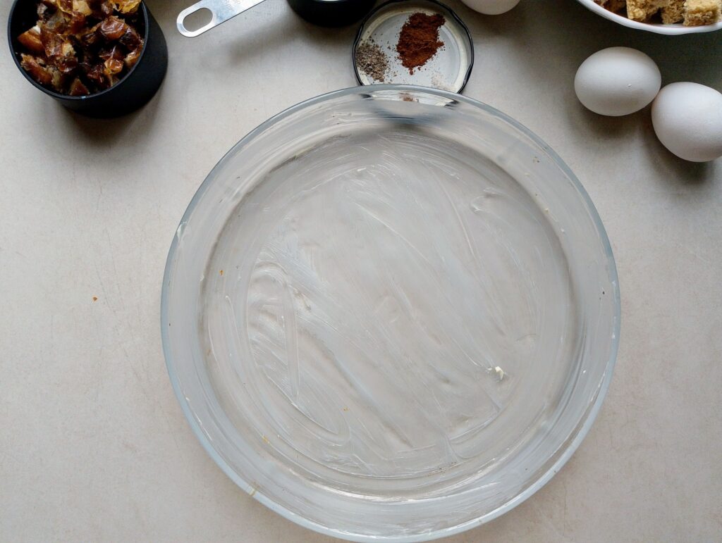 Greasing the casserole dish with butter for the bread and butter pudding