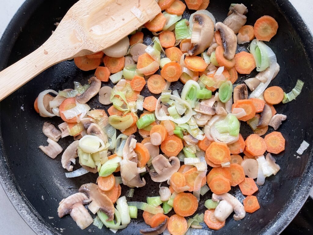 Sauteing carrots, leeks, and button mushrooms for the from scratch Chinese noodle soup