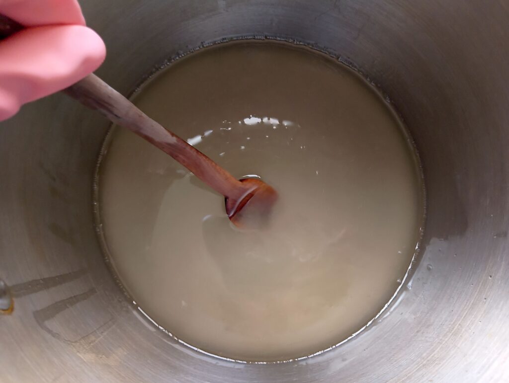 Mixing the lye solution into the melted coconut oil