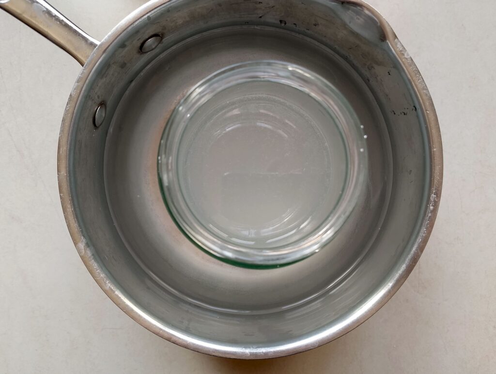 Cooling the jar with lye solution in a saucepan of cold water
