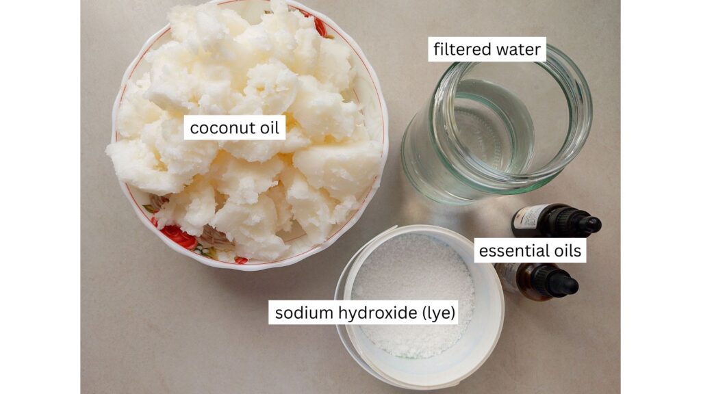 Ingredients for coconut oil soap arranged on a counter top: coconut oil, water, sodium hydroxide, and essential oils