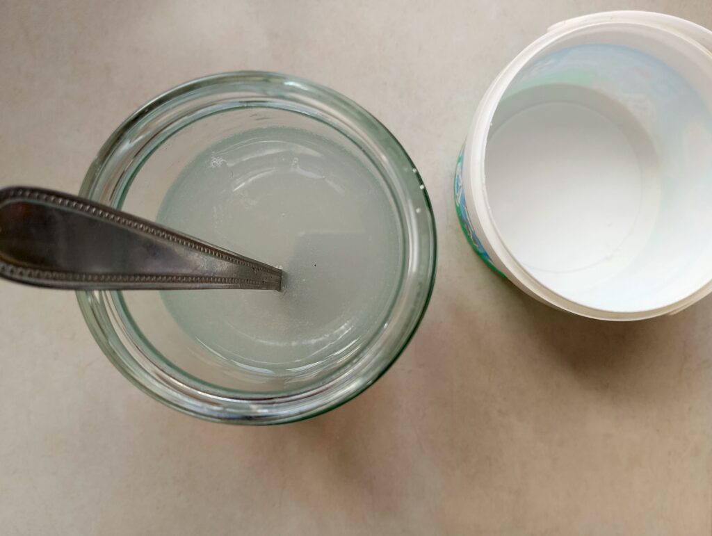 Adding soap lye into a jar of filtered water