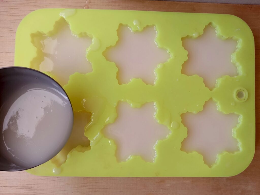 Ladling the coconut oil soap into soap molds