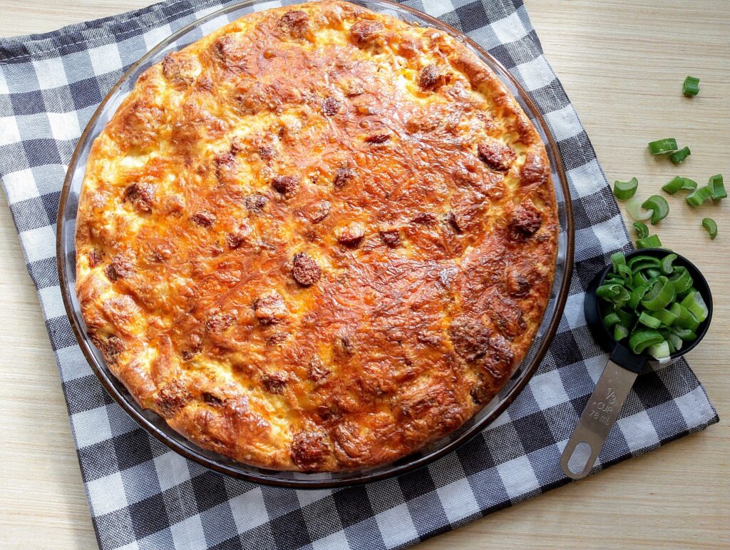 Freshly baked Amish breakfast casserole with sausage, ready to be garnished with fresh green onions