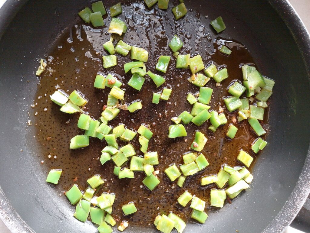 Sauteing chopped bell pepper in sausage grease