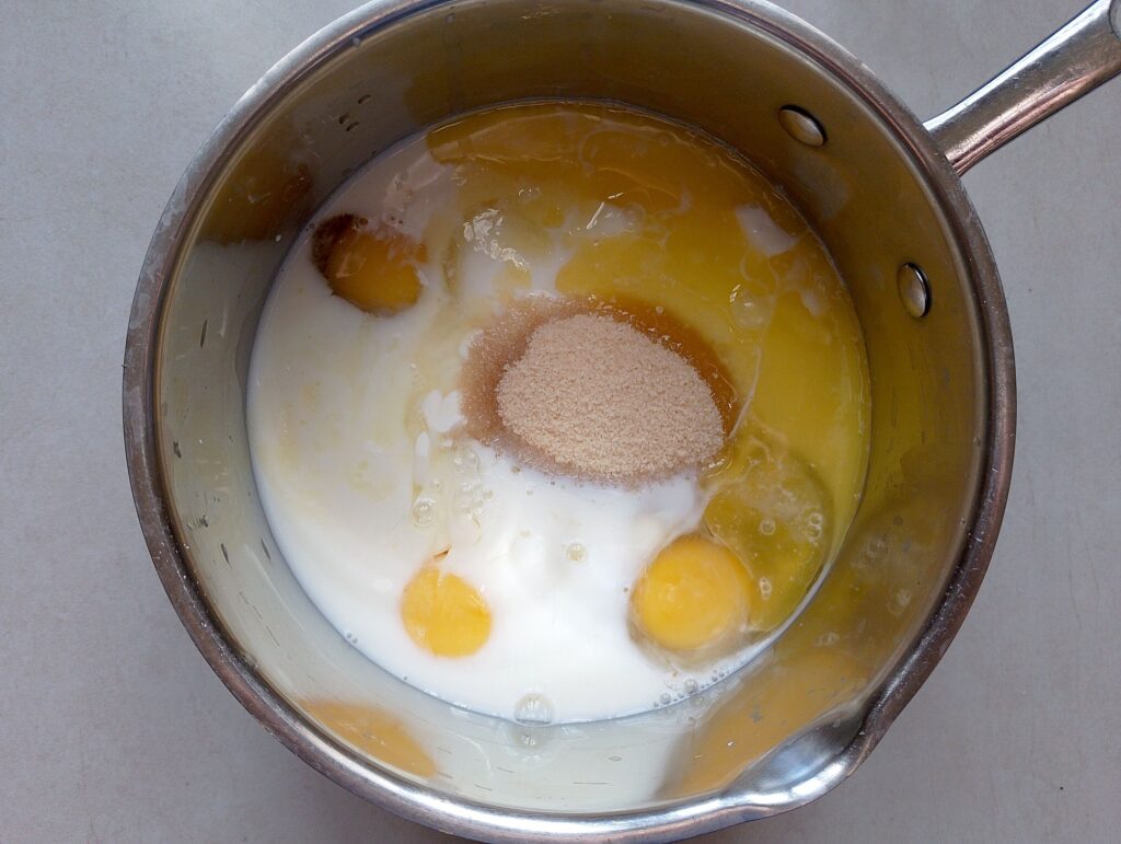 Eggs, milk, cream, melted butter, and brown sugar in a mixing bowl