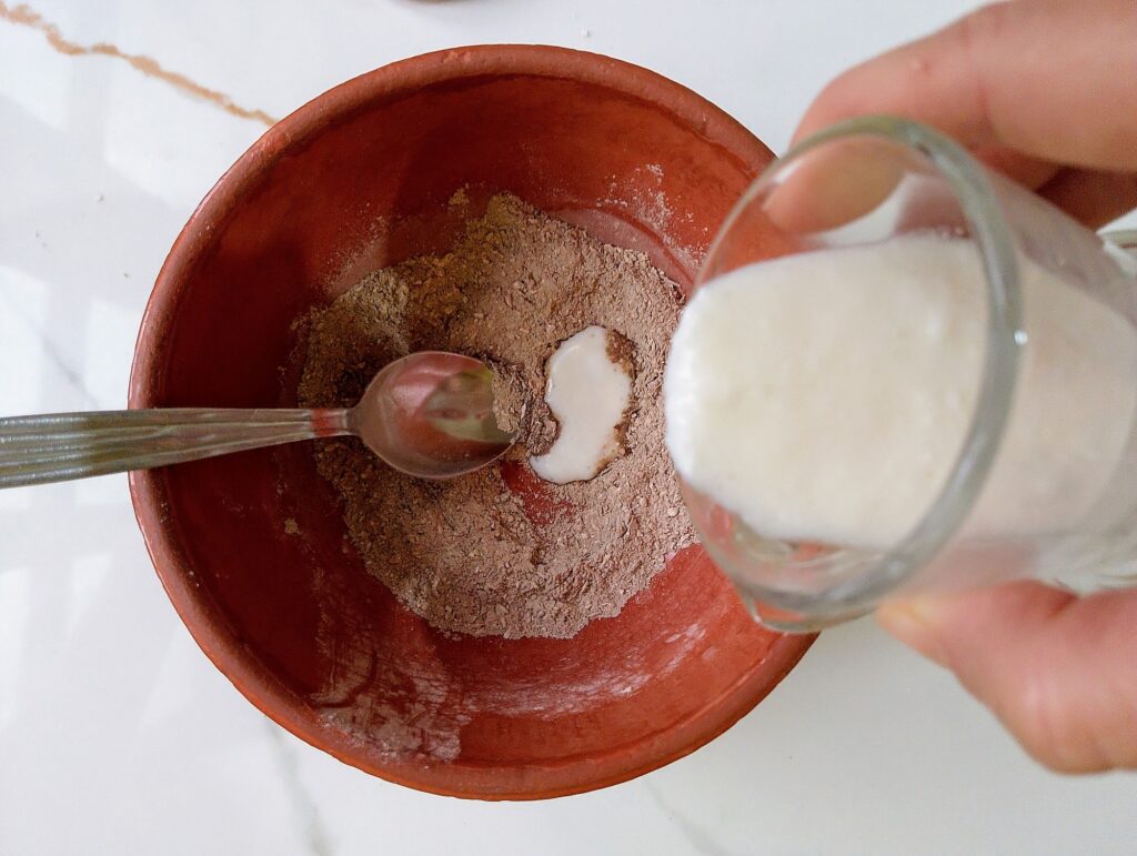 Mixing kefir into raw honey, ground oatmeal, ground lavender, and clay to make the face mask
