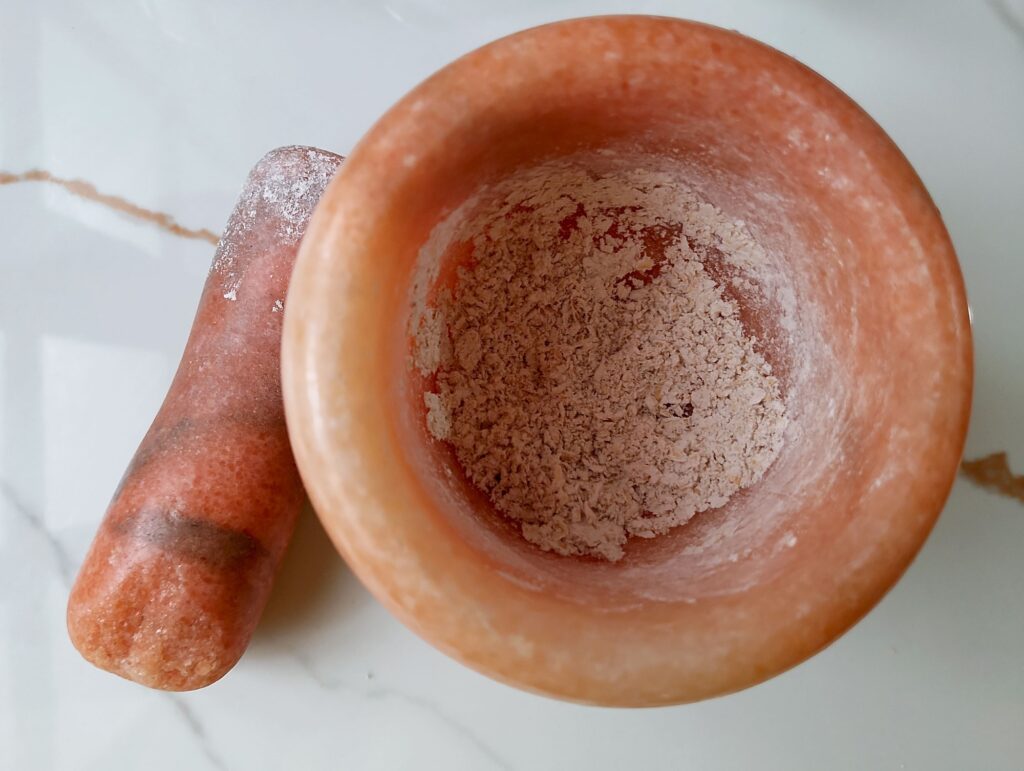 Grinding oatmeal in a mortar for the face mask